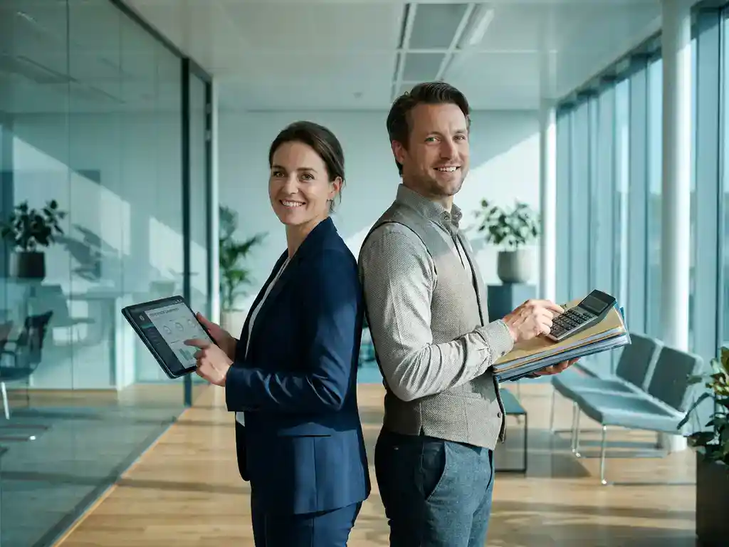 Recruiter en salarisadministrateur staan rug aan rug in een modern Nederlands kantoor met groot raam en zachte teal-blauwe tinten.